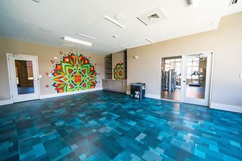 A room with a blue tiled floor and a large mandala painting on the wall at The Collective NoDa, Charlotte
